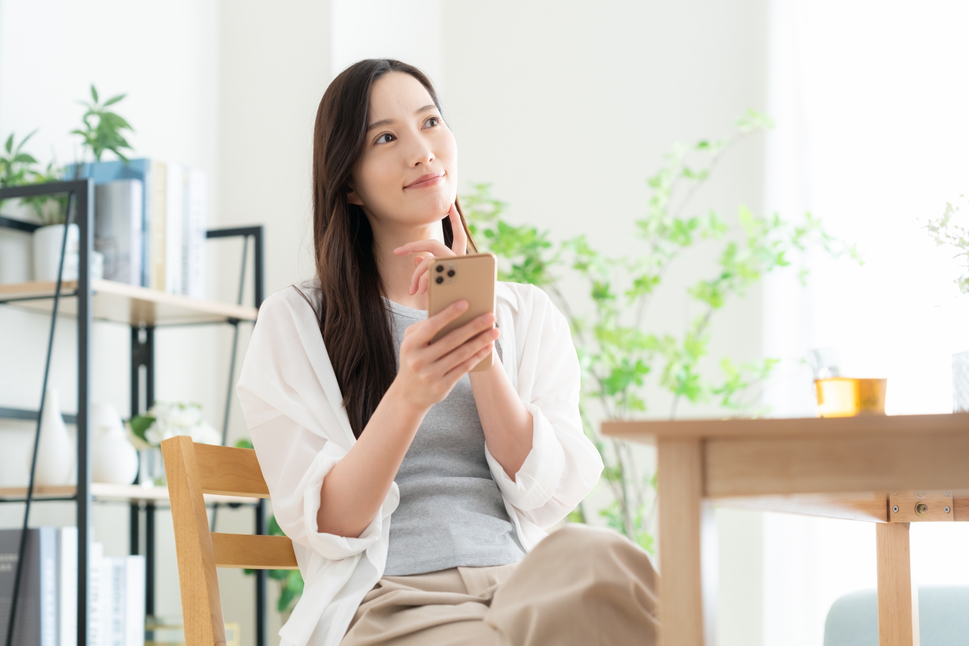リビングでスマホを見る若い女性