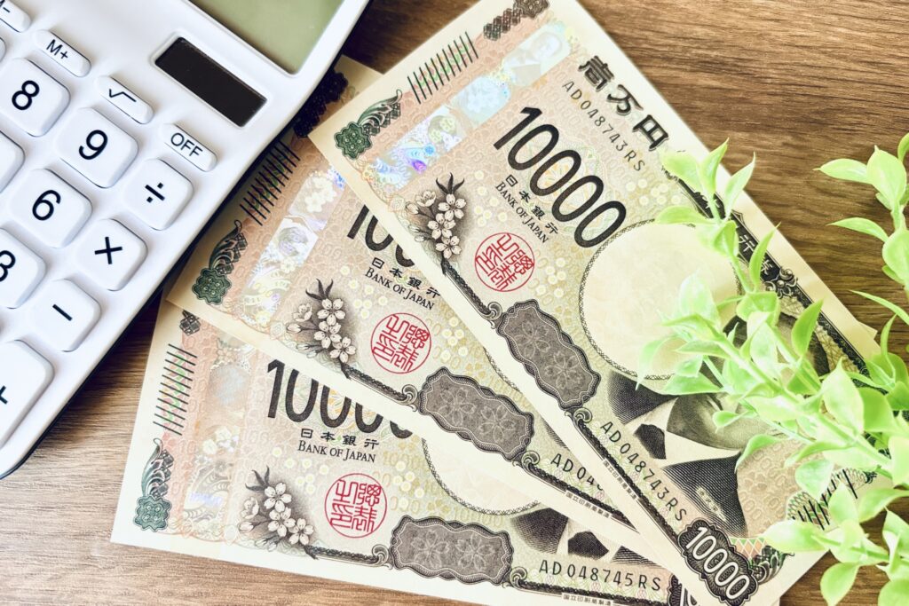 木目の机に現金1万円と電卓