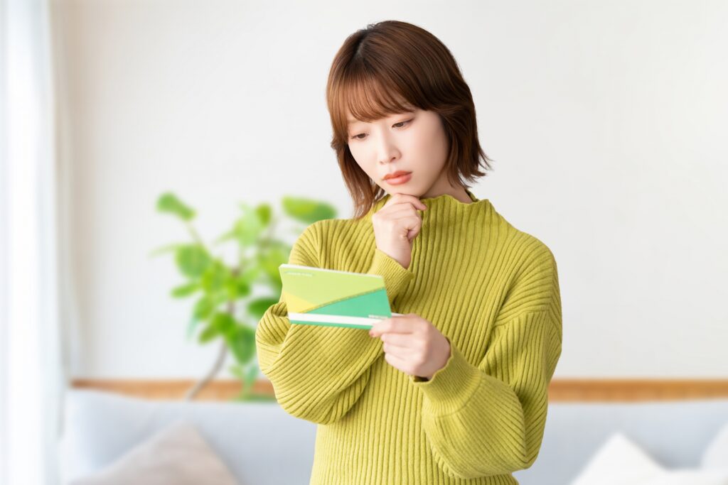 通帳を見て考える女性