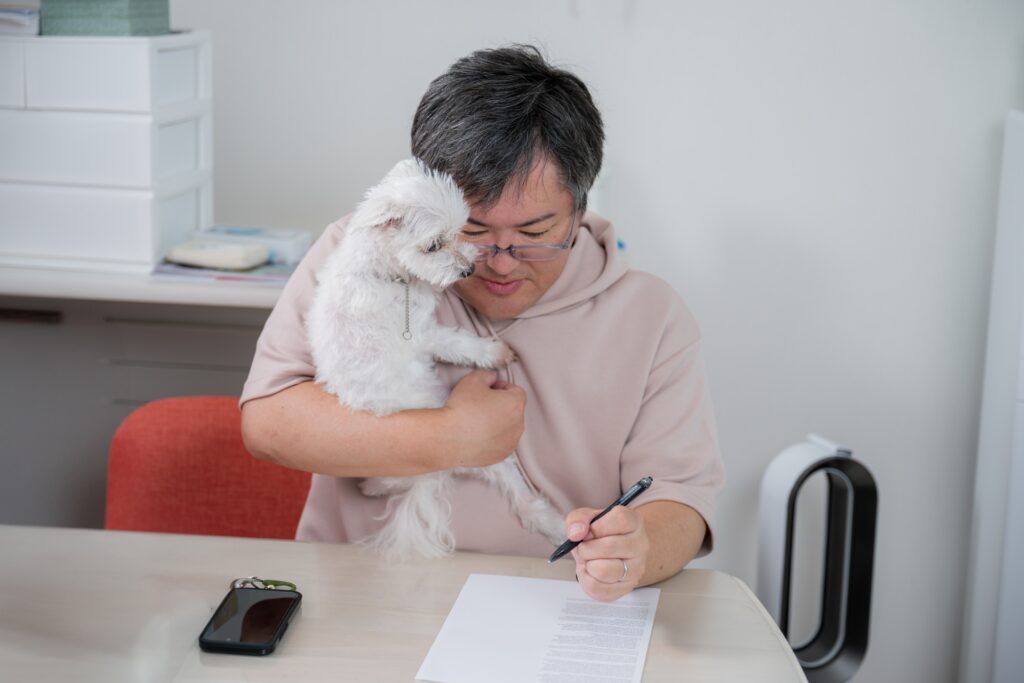ペットと書面を書く中年私服男性