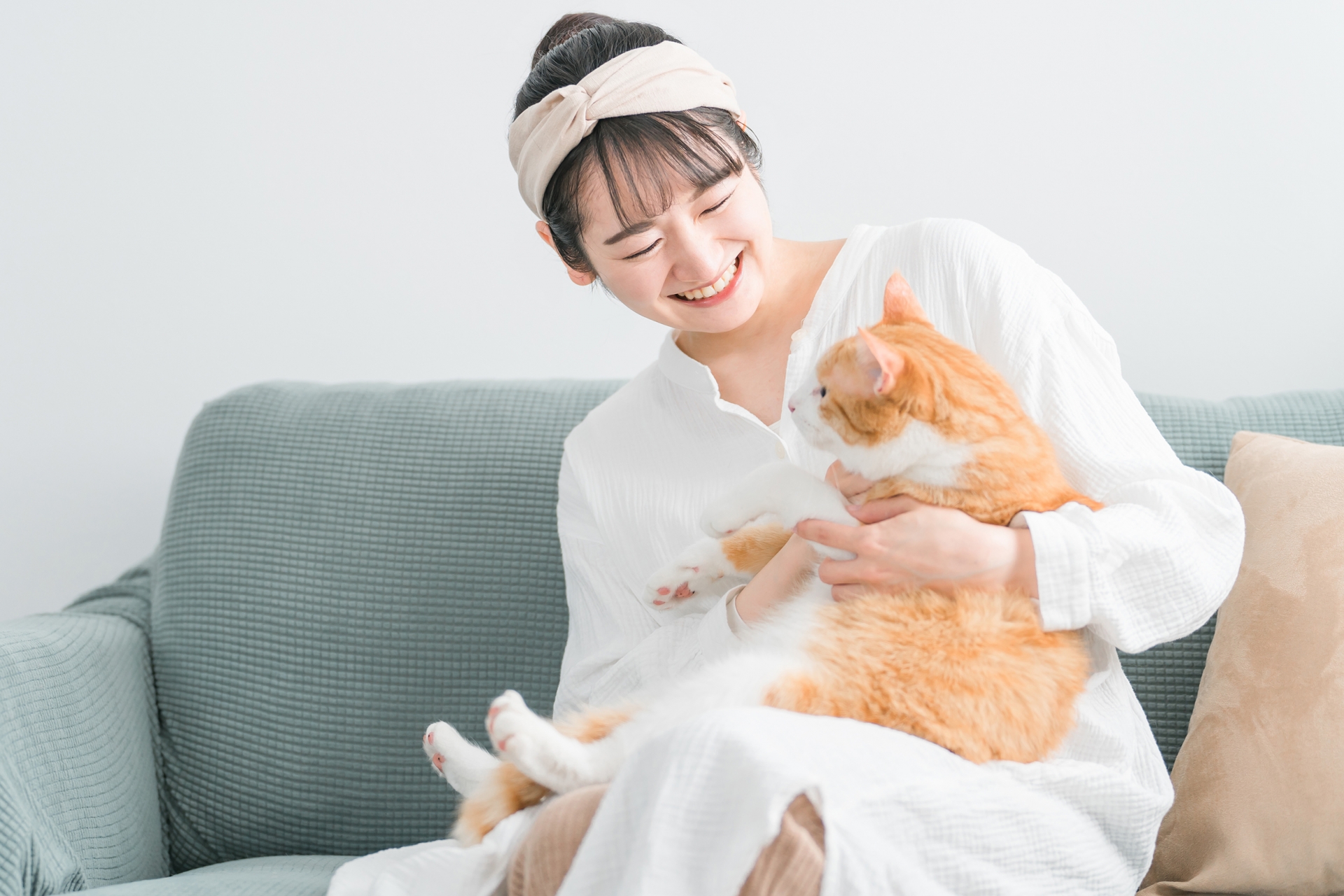 家で猫を抱っこする日本人女性